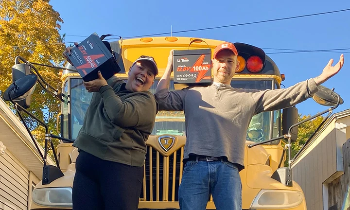 excited couple powering their school bus RV adventure with two lightweight and powerful LiTime 100Ah LiFePO4 batteries