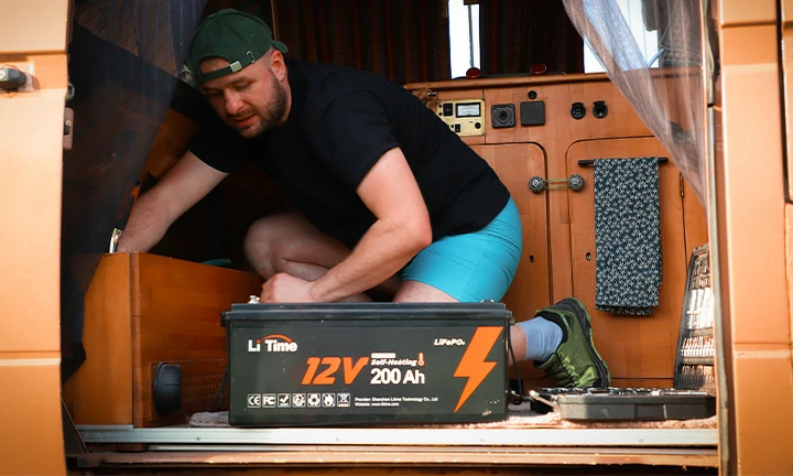 a man works on the electrical system inside his camper van, with a LiTime 12V 200Ah LiFePO4 battery ready for installation
