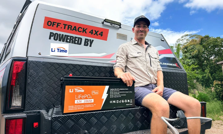 a man with his Off-Track 4x4 camper, which is 'Powered By' LiTime, sitting next to his 12V 200Ah LiFePO4 Plus battery
